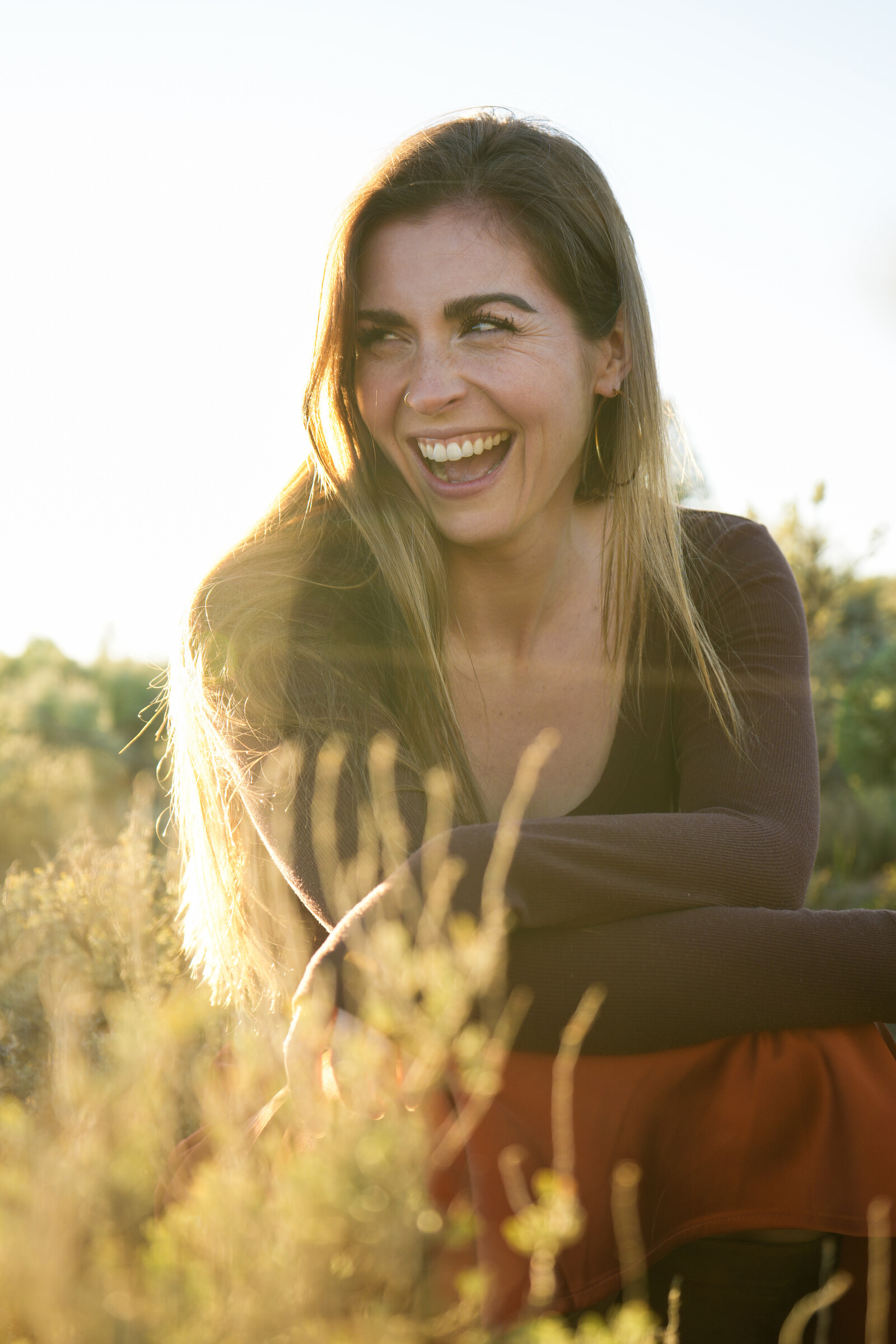 Emily smiling outdoors in golden afternoon light